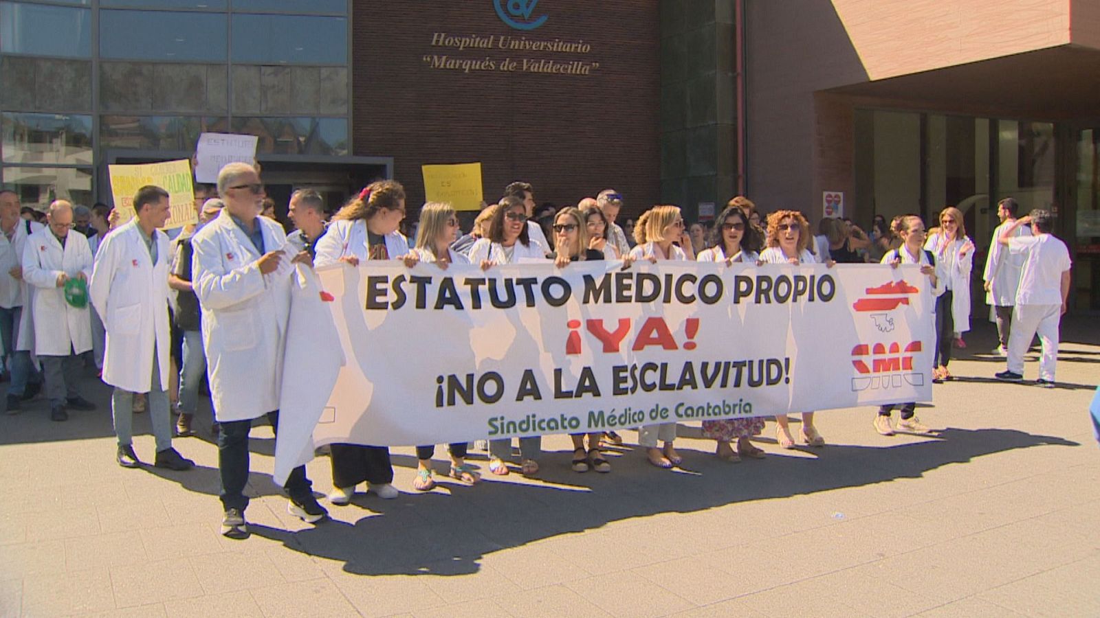 Profesionales sanitarios protestan frente al Hospital Universitario Marqués de Valdecilla con una pancarta que exige "ESTATUTO MÉDICO PROPIO ¡YA! ¡NO A LA ESCLAVITUD!".