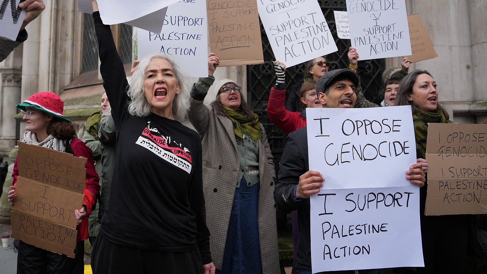 Manifestantes con pancartas contra el genocidio y a favor de Palestine Action protestan frente a un edificio histórico de Reino Unido