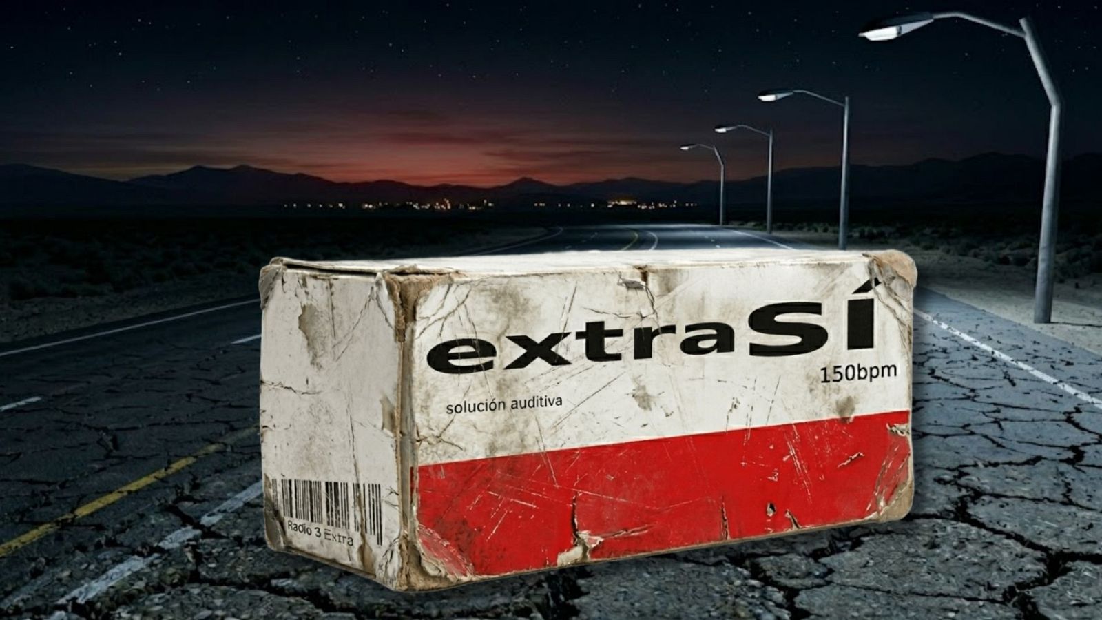 Caja de cartón desgastada con "extraSí", "solución auditiva", "150bpm" y "Radio 3 Extra" sobre carretera agrietada de noche, bajo cielo estrellado y resplandor lejano.