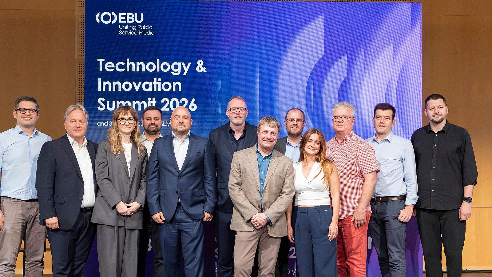 Once profesionales, nueve hombres y dos mujeres, posan sonrientes ante una pantalla con el logo de EBU y el título "Technology & Innovation Summit 2026".