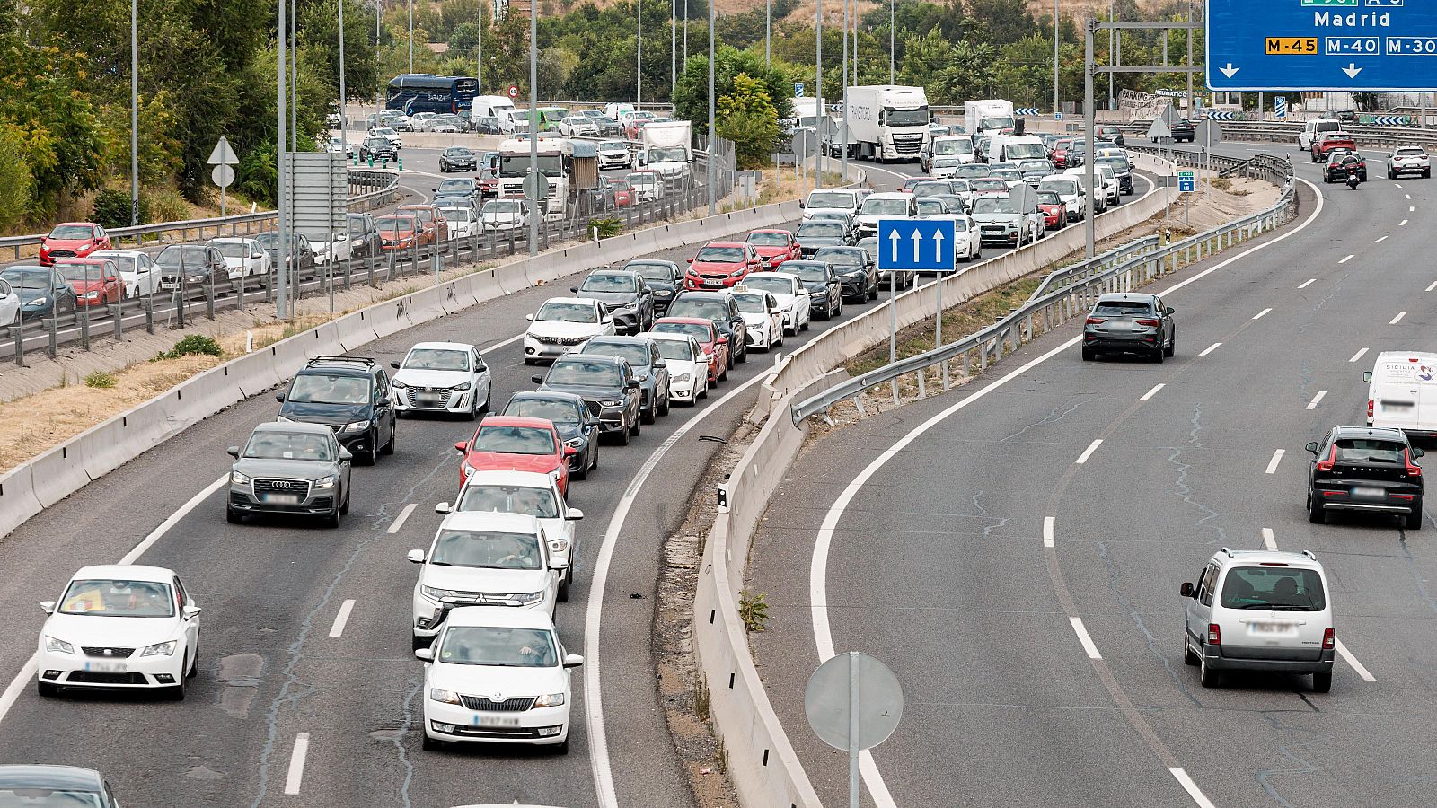 Vista aérea de la A-3 en Madrid el 1 de agosto de 2025, con tráfico denso. Numerosos vehículos, señales de tráfico y vegetación flanquean la autopista.