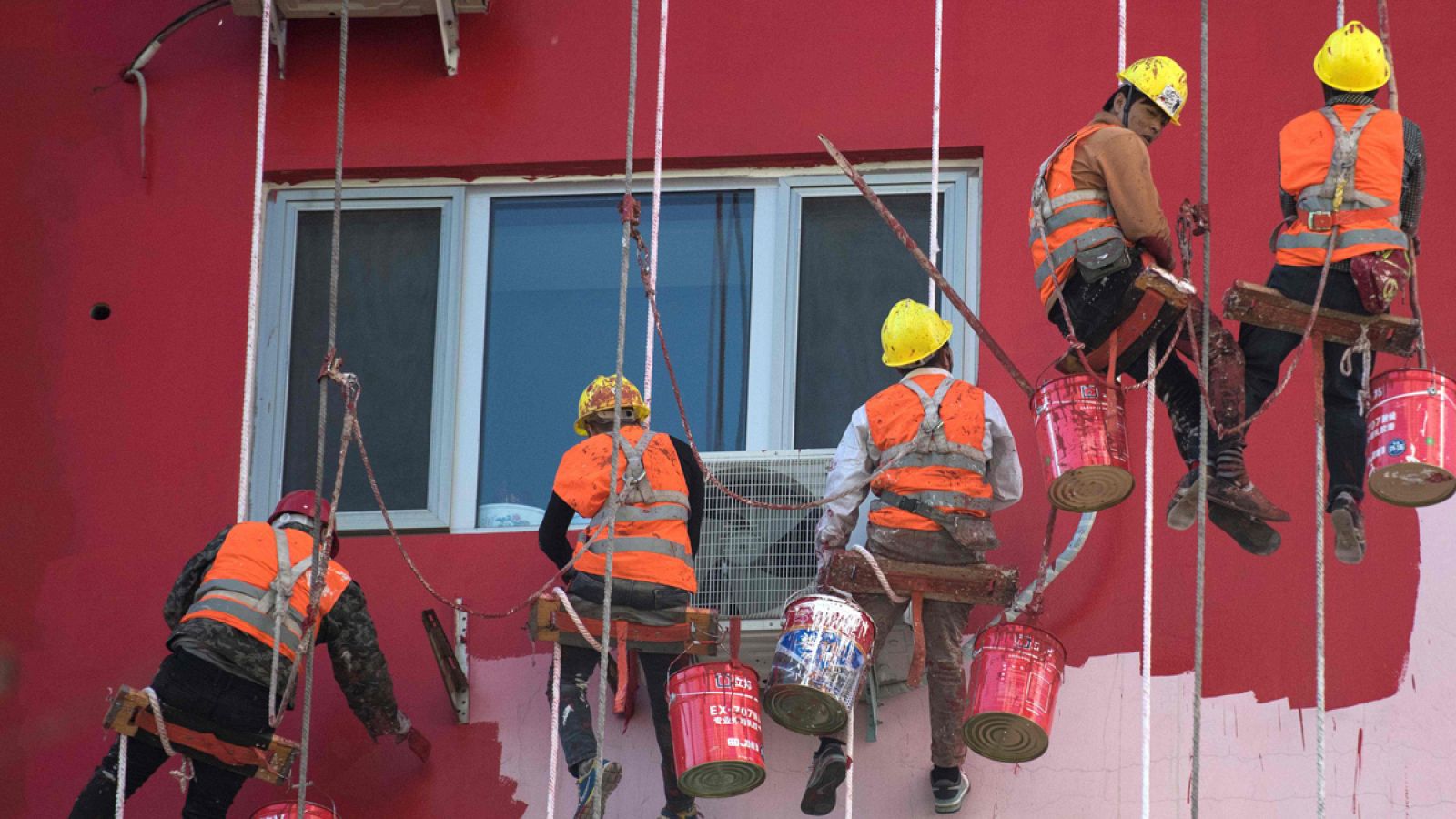 Un grupo de trabajadores chinos pinta un edificio residencial en Beijing