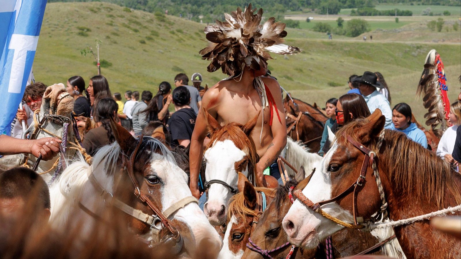 Personas ataviadas como nativos americanos sobre caballos, conmemorando el aniversario de Little Big Horn