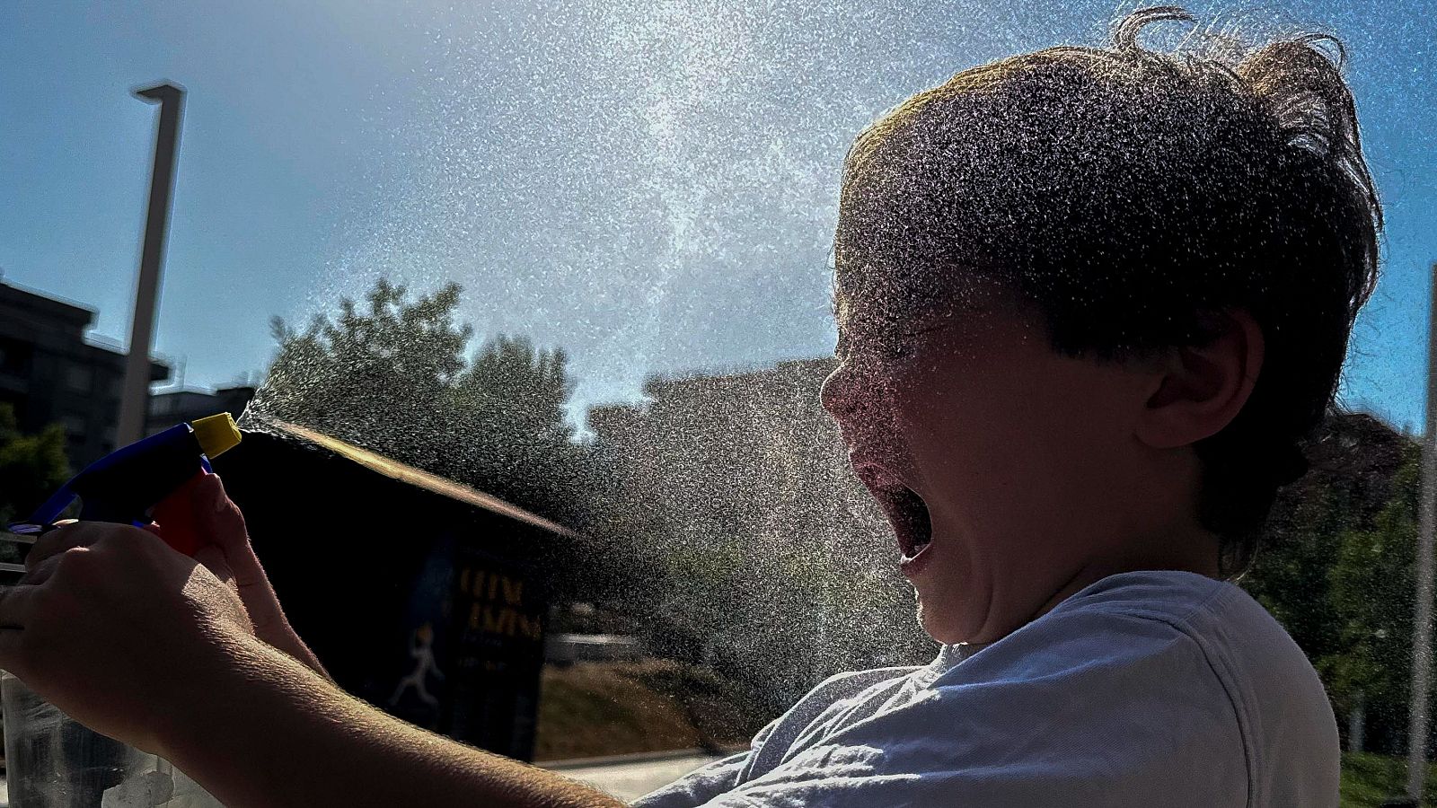Un nen es tira aigua per sobre per intentar apaivagar la calor