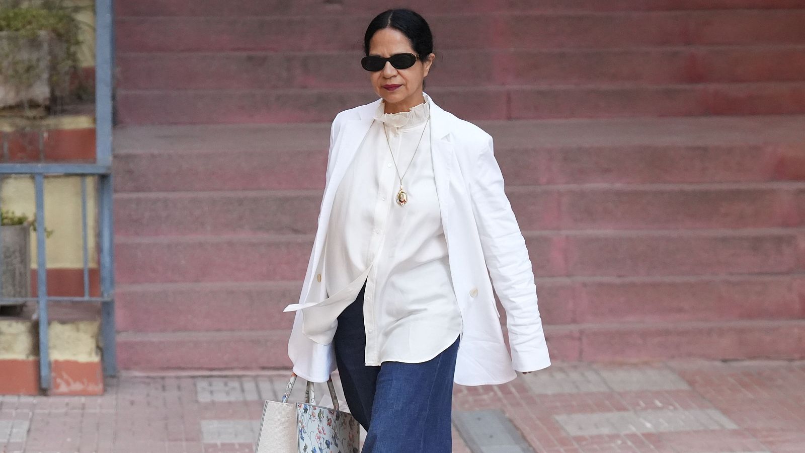 Julia Luderwaldt, terapeuta de familia, llega al Juzgado n4 de Martorell el 30 de junio, vestida con blazer blanco, camisa blanca y pantalones azul oscuro, gafas de sol y bolso tote.