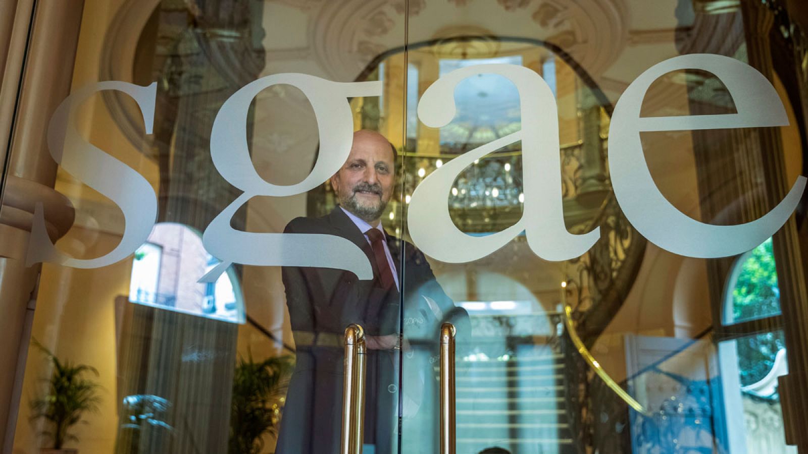 El presidente de la SGAE, José Miguel Fernández Sastrón, posa detrás de la puerta de la sede