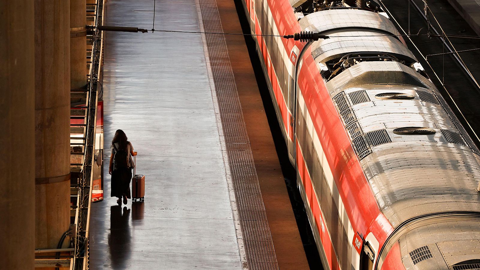 Una pasajera camina en una estación de tren.