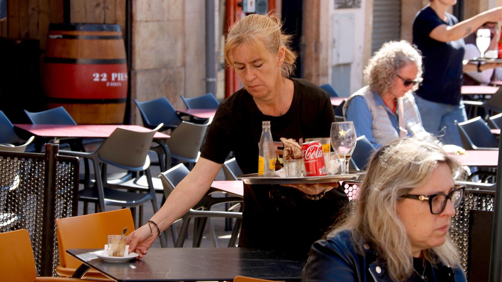 Una cambrera treballant en una terrassa d'un bar de la plaça de la Font a Tarragona