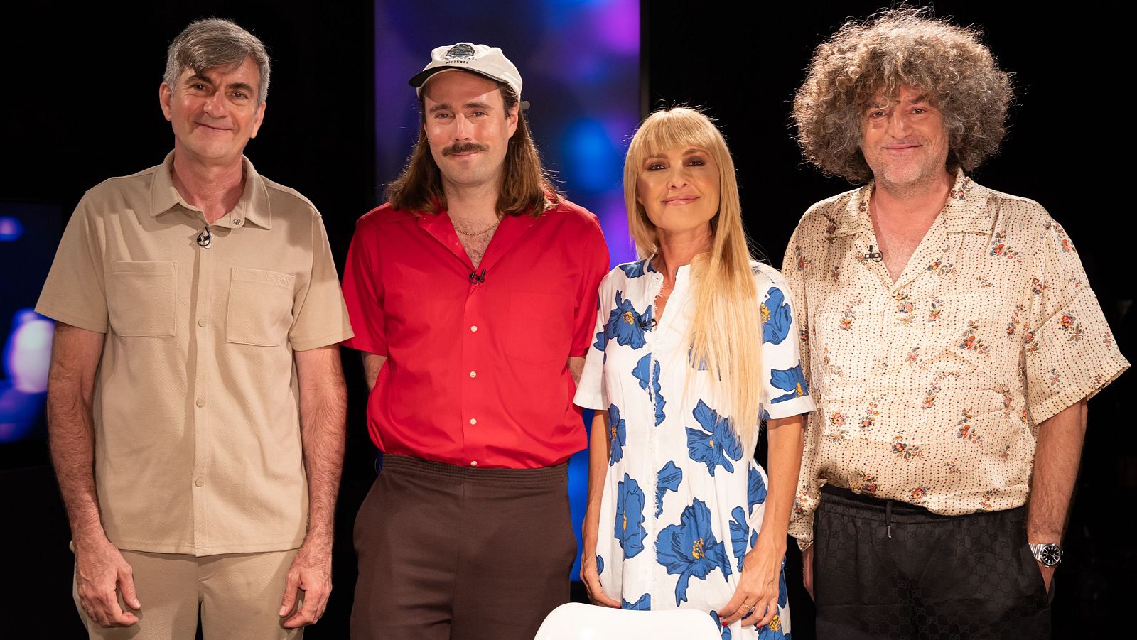 Antonio Hens, Pablo Larcuen, Cayetana Guillén Cuervo y Óscar Romagosa, cuatro figuras del audiovisual español, sonríen a la cámara en un estudio con luces azules y moradas.
