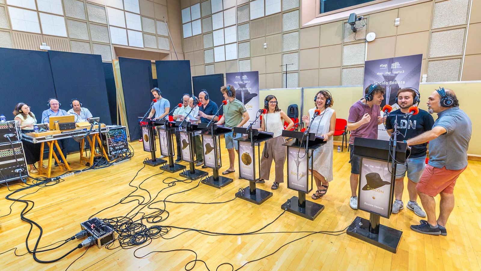 Ensayo de "El Buscón", ficción sonora de RNE, en un estudio de grabación con equipo técnico y participantes con auriculares y micrófonos.