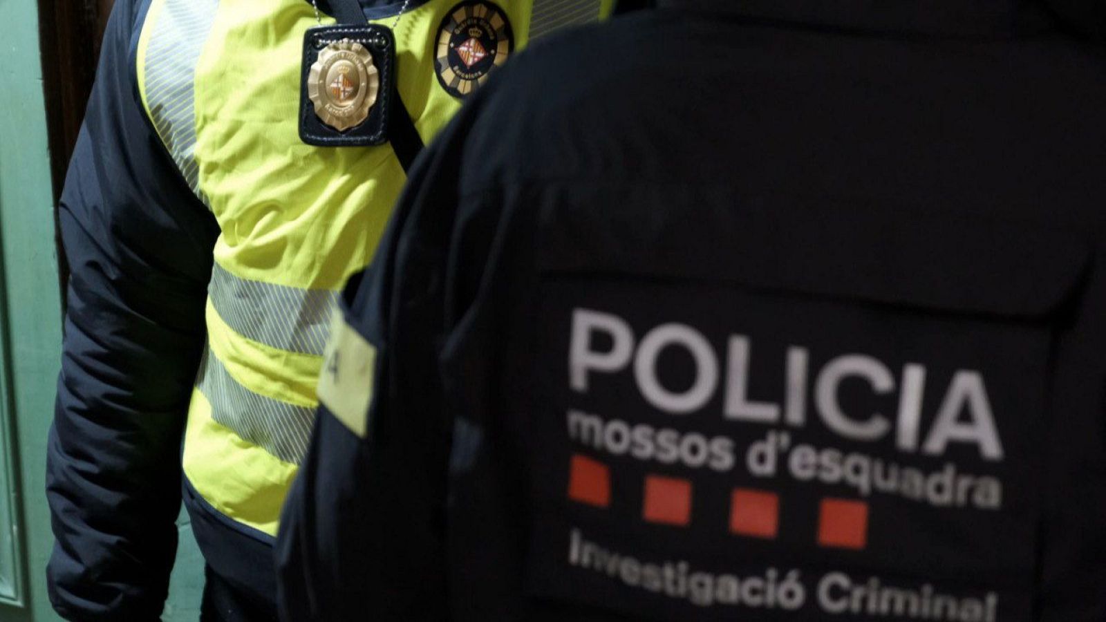 Un agent dels Mossos d'Esquadra davant d'un altre de la Guàrdia Urbana de Barcelona