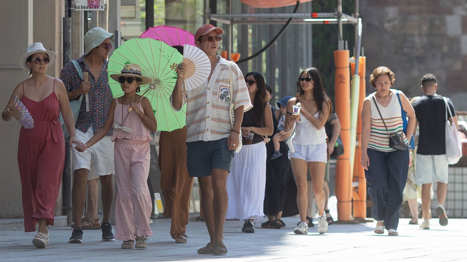 Els turistes es protegeixen del sol i la calor al centre de Barcelona