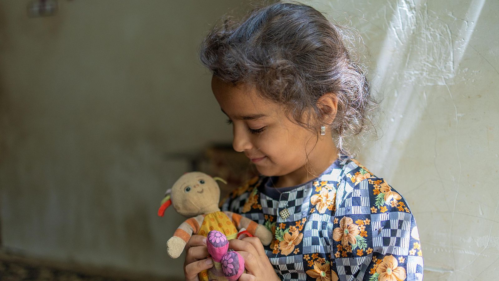 Momtaaz juega Millones de niños están en riesgo de pobreza como consecuencia de la crisis en Oriente Mediouna muñeca en su casa en Afganistán
