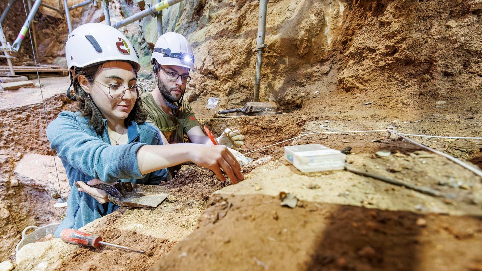 Dos jóvenes arquológos trabajando en un yacimiento