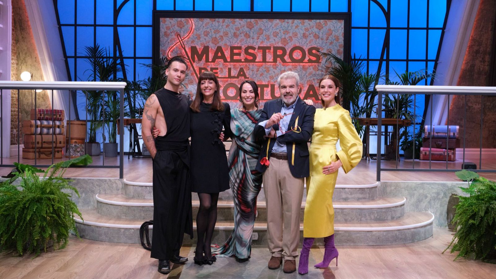 Cinco personas posan en el escenario de "Maestros de la Costura". De izquierda a derecha: Palomo Spain, María Escoté, Raquel Sánchez Silva, Lorenzo Caprile y una mujer. Todos sonríen a la cámara.