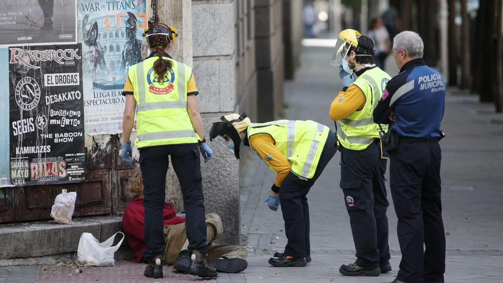 Tres trabajadores del Samur y un policía atienden a una persona sin hogar en Madrid