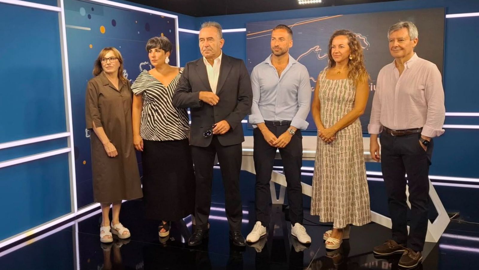 Grupo de seis personas, incluyendo a Pau Fons, director de RTVE en Islas Baleares, posando en un estudio con fondo azul y gráfico abstracto.