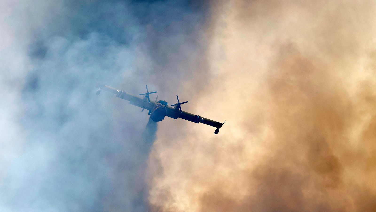 Un avión anfibio Canadair realiza una descarga de agua sobre un incendio forestal que arde en Pontevès, en el sur de Francia.
