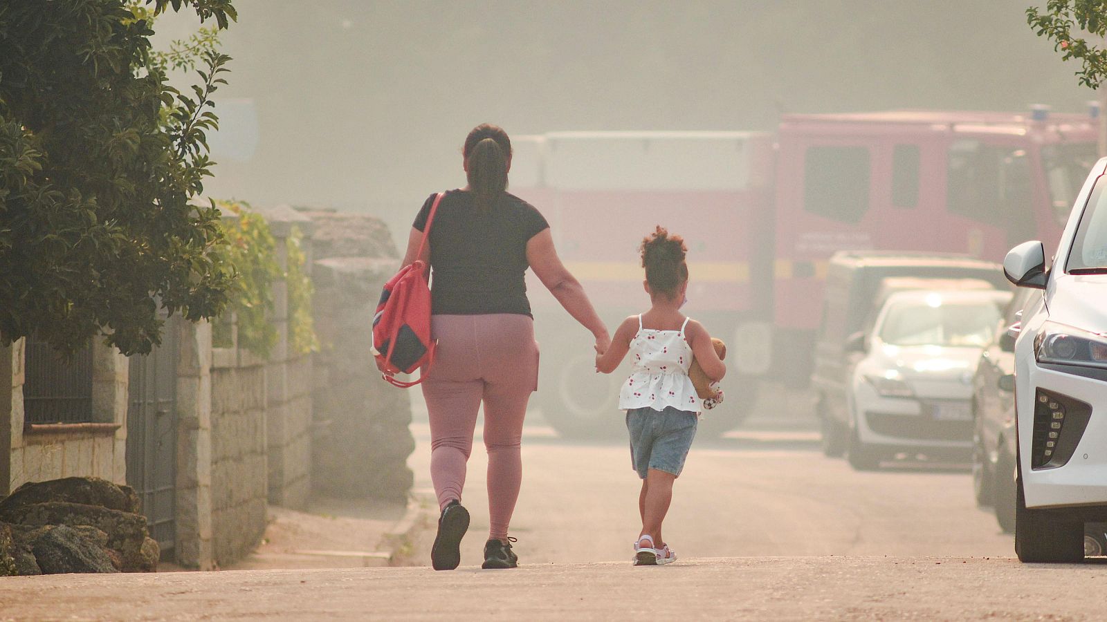 Una madre y una niña camina de la mano, a 24 de julio de 2026, en Burgohondo, Ávila, Castilla y León (España)