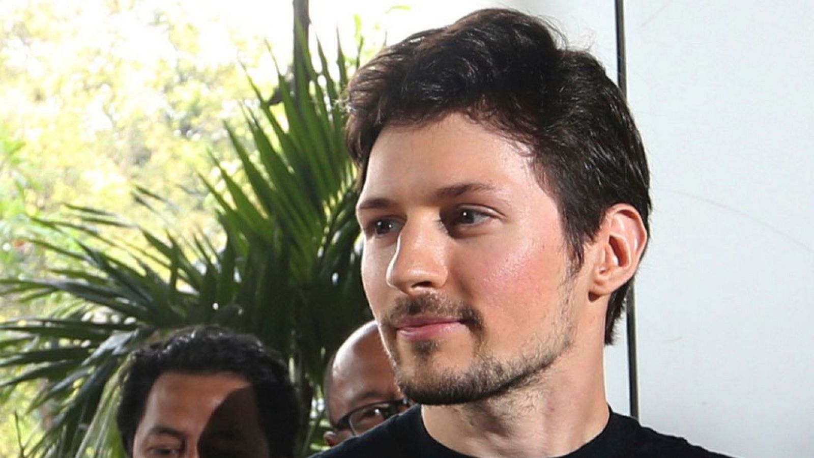 Retrato de Pavel Durov, cofundador de Telegram, con barba y bigote cortos, en un evento en Yakarta el 1 de agosto de 2017. Fondo dividido entre blanco y vegetación.