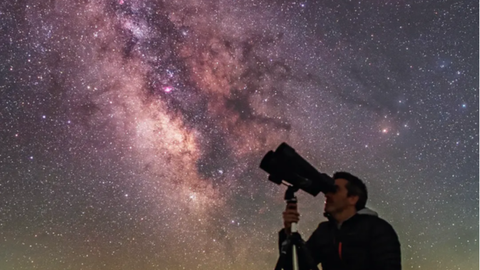Oscar Blanco observa la Vía Láctea a través de un binocular astronómico o telescopio en una escena nocturna estrellada.