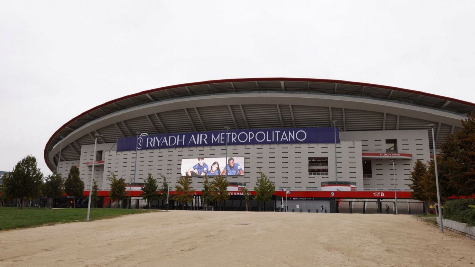 Pancarta de Riyadh Air en el estadio Metropolitano. Pantalla gigante con tres personas (dos hombres y una mujer) con camisetas azules.  Posible pancarta de Civitas Metropolitano.