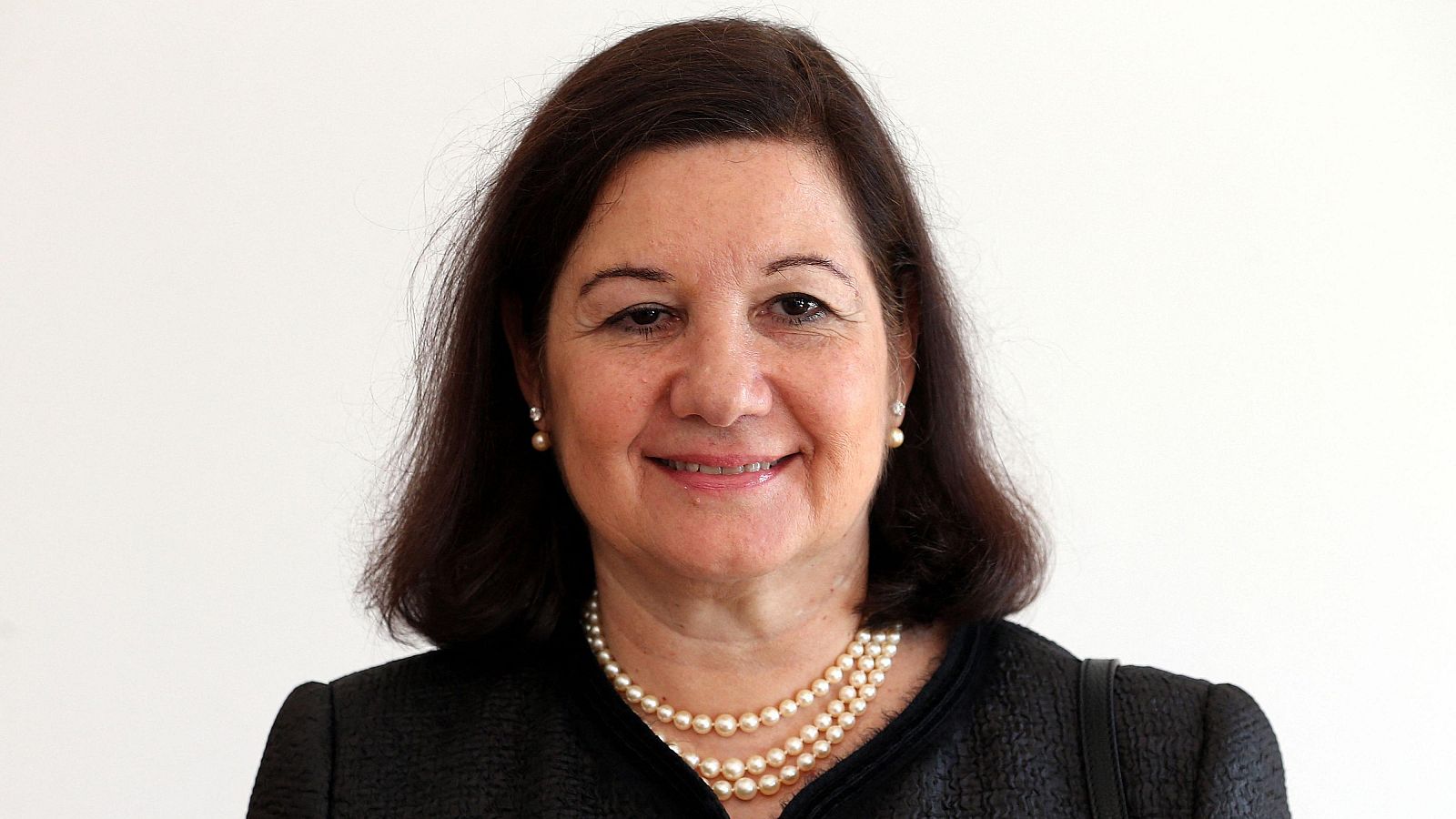 Maria Luiza Ribeiro Viotti, embajadora de Brasil en Washington, posa con una sonrisa serena, luciendo joyas de perlas y una chaqueta oscura. Fondo blanco.