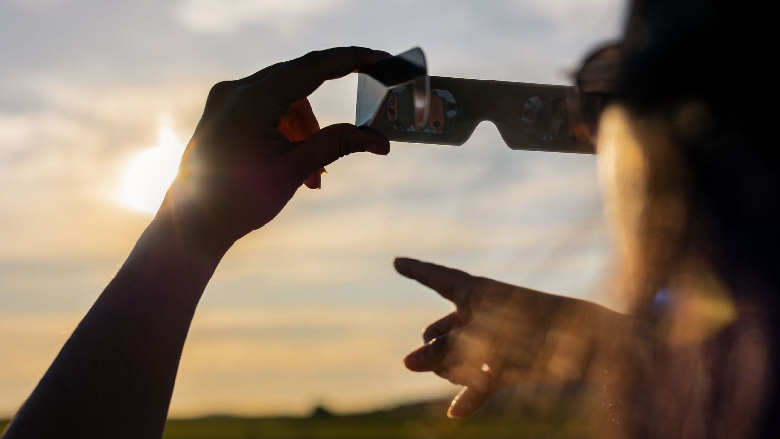 Una persona observa a través de unas gafas un eclipse.