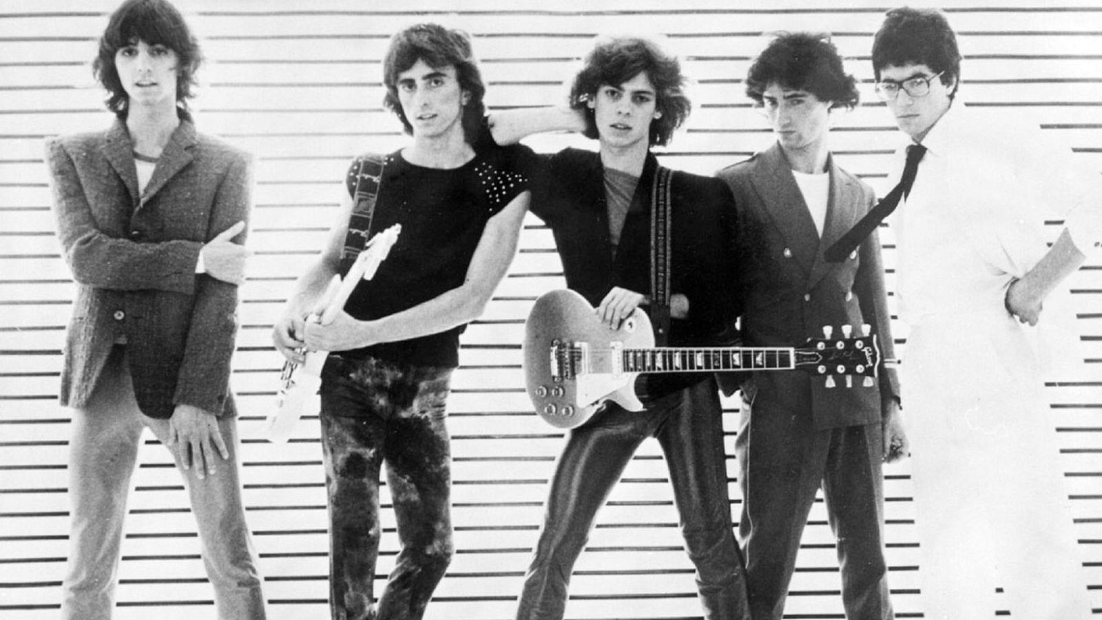 Cinco jóvenes músicos posan en fila, dos con guitarras, en una foto en blanco y negro de estilo rock de finales de los 70 o principios de los 80. Se identifica a Felipe Lipe a la derecha.