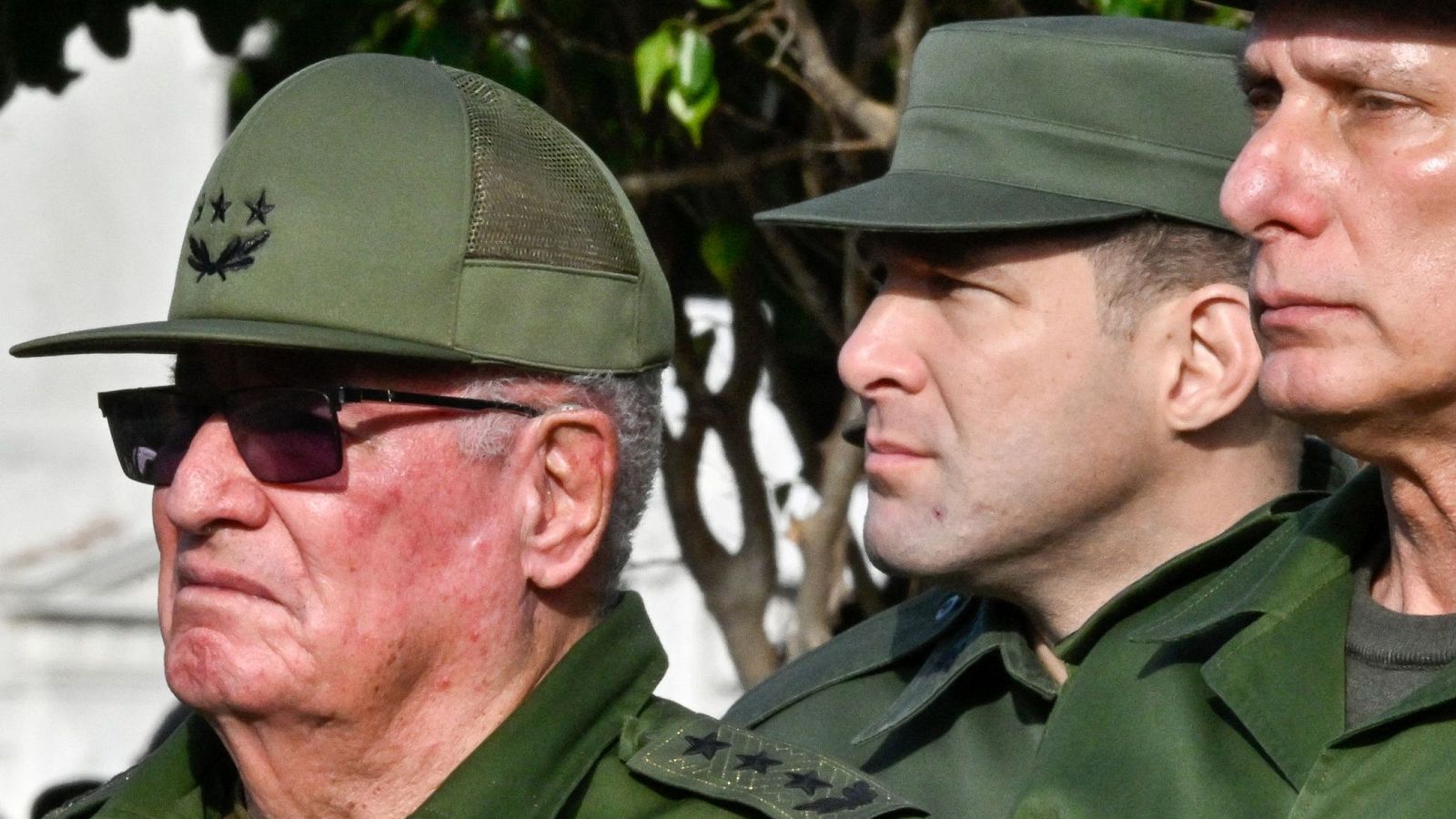 Tres hombres con uniformes militares verdes y gorras, de perfil. Álvaro López Miera, coronel Raúl Guillermo Rodríguez y Miguel Díaz-Canel. Se aprecian insignias de tres estrellas doradas y corona de laurel.