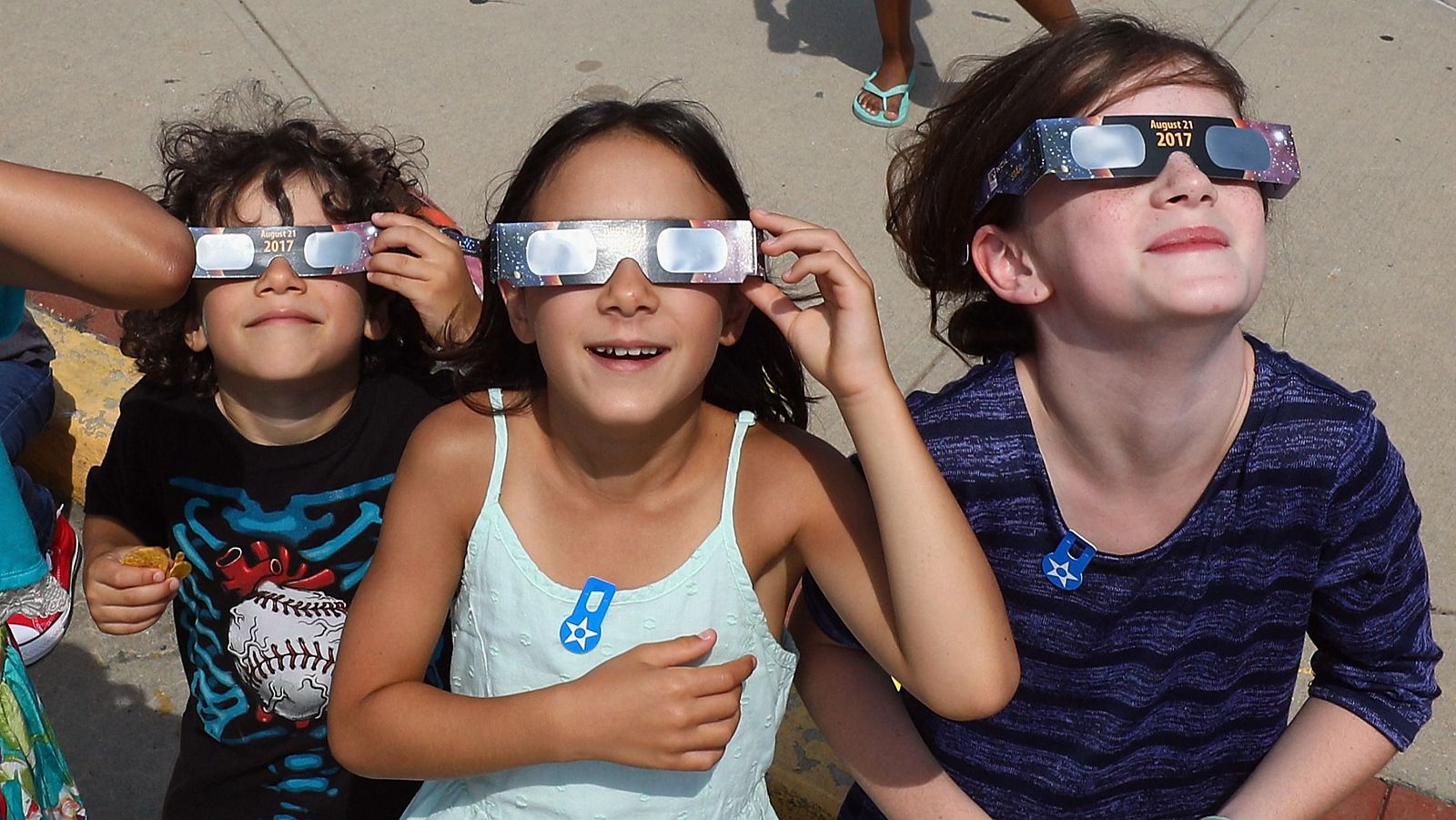 Unos niños observan un eclipse con unas gafas homologadas.