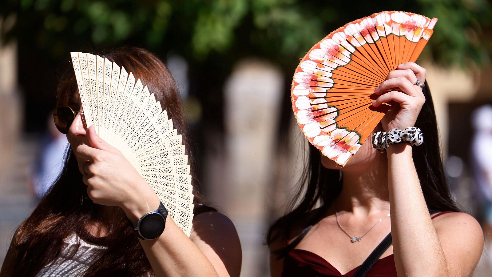 Turistas se protegen con abanicos para aliviar las altas temperaturas en Córdoba.