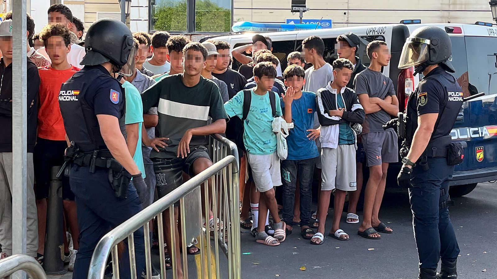 Menores migrantes esperan para su filiación frente a la Jefatura Superior de la Policía Nacional en Ceuta este lunes.
