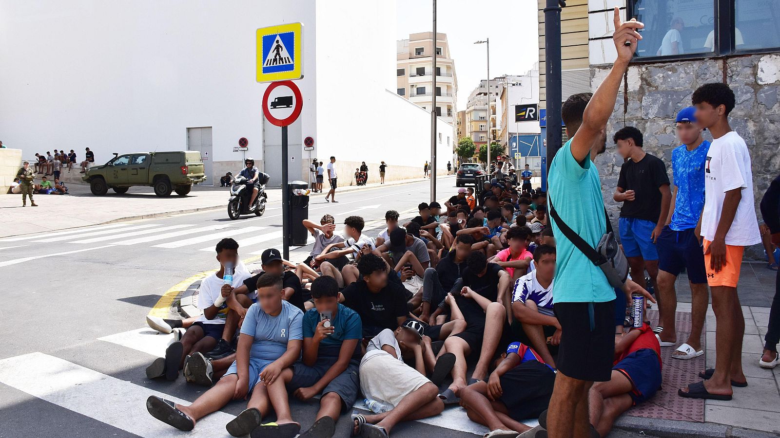 Un grupo de menores espera para entrar en la comisaría de la Policía Nacional en Ceuta.