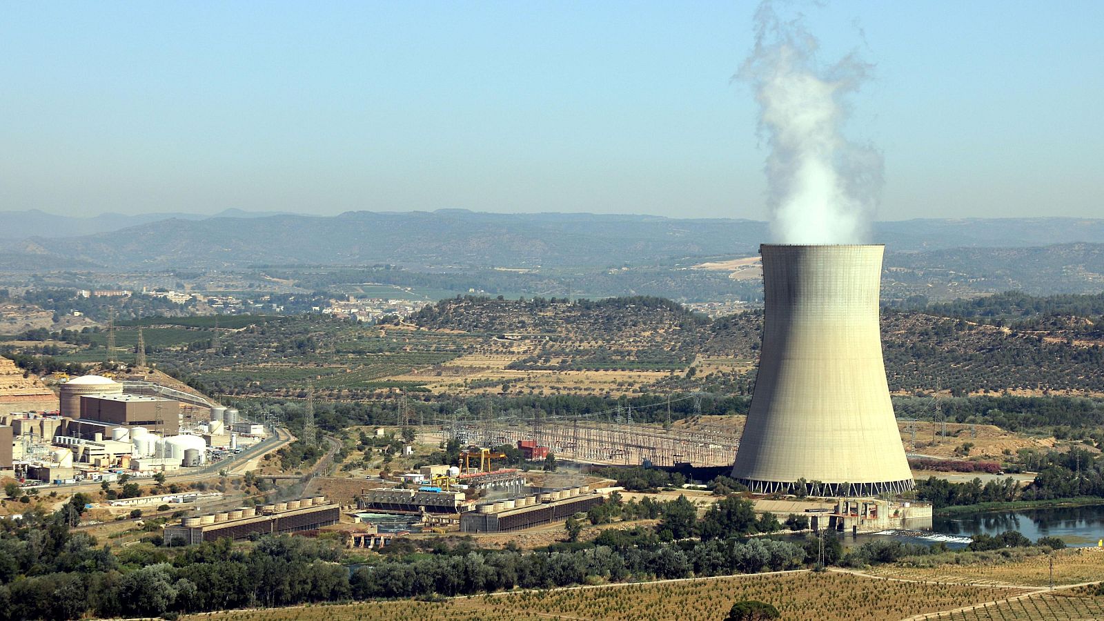 Pla general de la central nuclear d'Ascó, a la Ribera d'Ebre, amb la xemeneia fumejant a la dreta i els dos reactors a l'esquerra