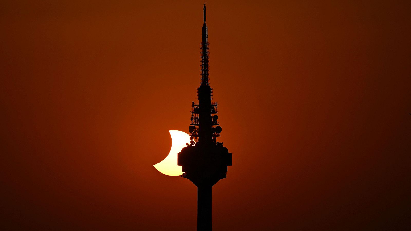 El Pirulí con el eclipse solar detrás