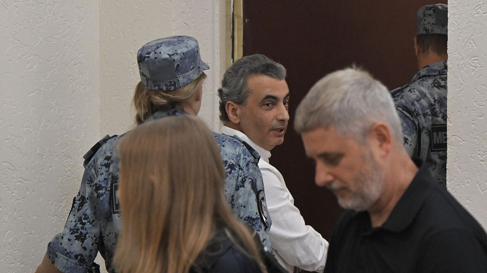 Lev Shlosberg es escoltado fuera de la sala del tribunal tras ser sentenciado a 11 años de prisión en Rusia