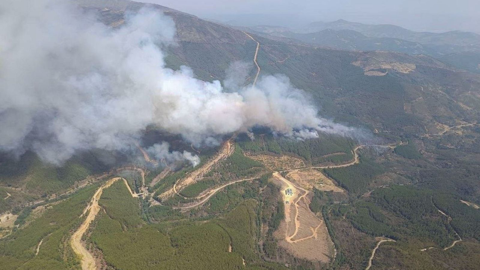 Vista aérea del incendio forestal en Pinofranqueado, Cáceres, con columnas de humo blanco cubriendo los valles de Las Hurdes.
