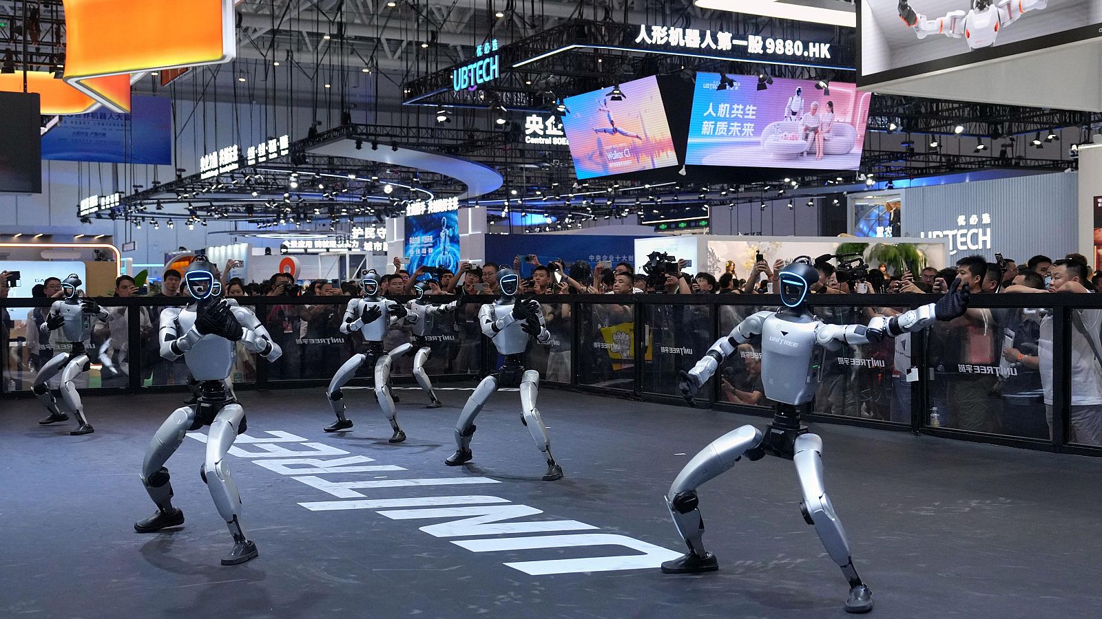 Varios robots humanoides de Unitree bailan en la World Robot Conference de Beijing este miércoles.