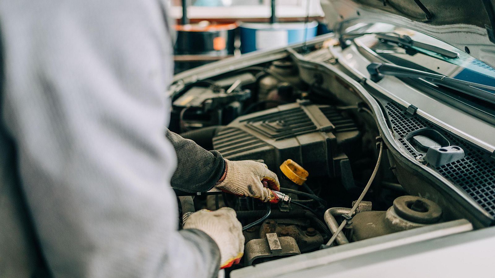 Mecànic reparant un cotxe convencional