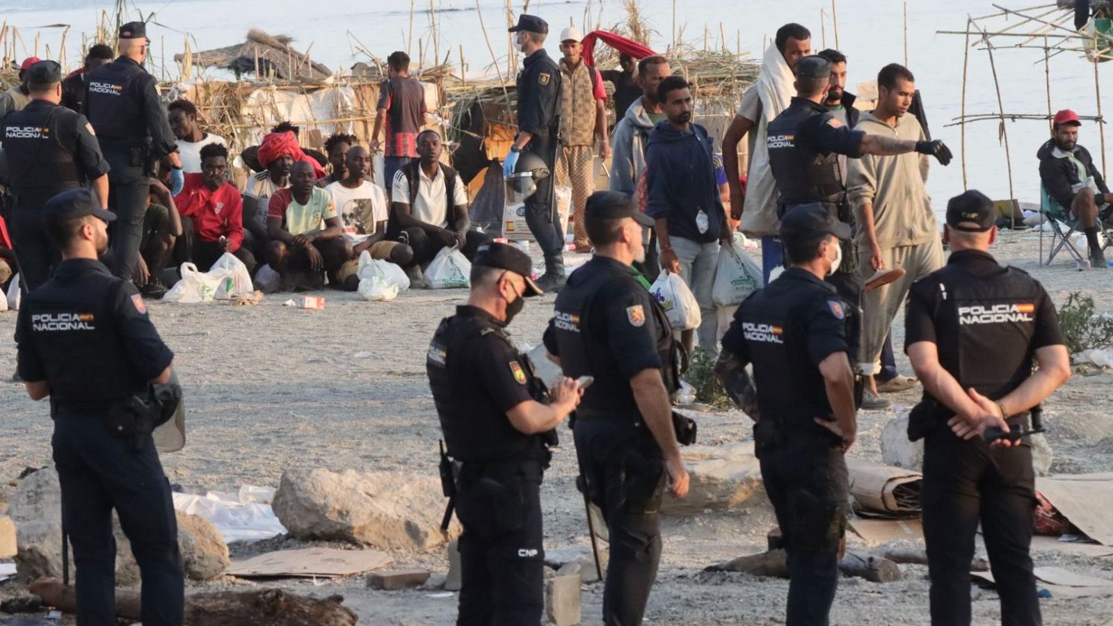 La Policía desaloja a los migrantes de la playa de Trampolín y los traslada a dos espacios habilitados por el Gobierno