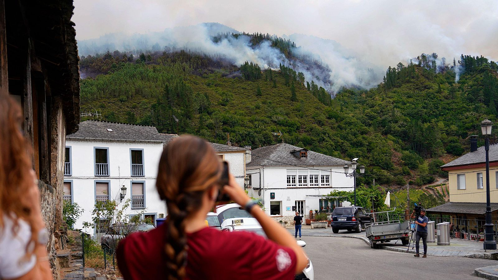 Varias personas observando el incendio que afectó a los alrededores de San Antolín de Ibias en 2025