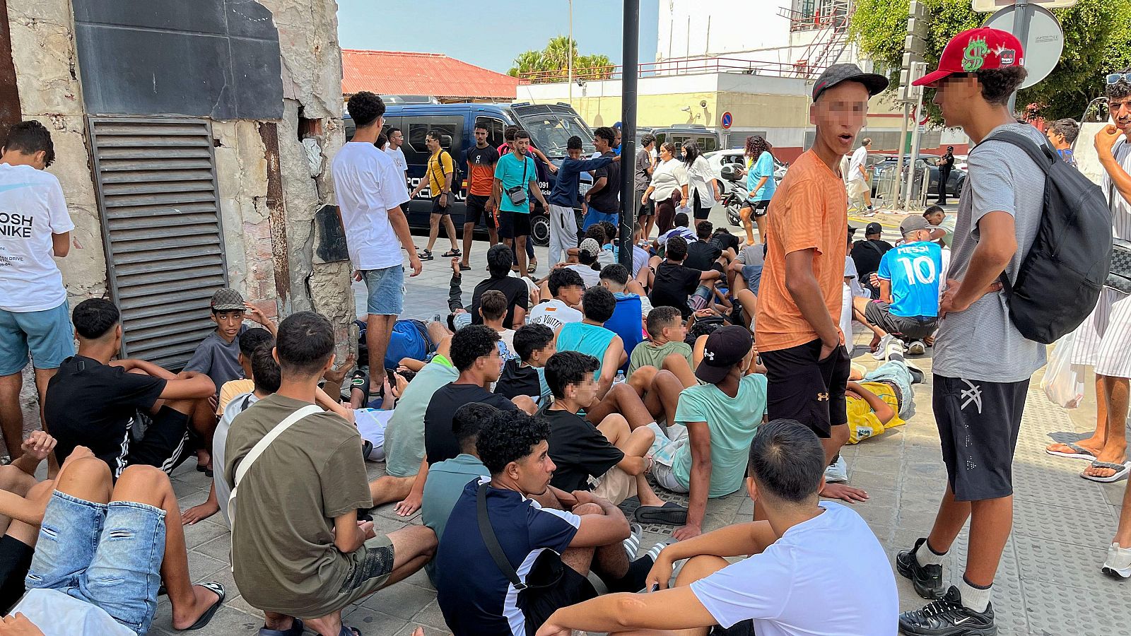 Multitud de menores migrantes esperan para su filiación frente a la Jefatura Superior de la Policía Nacional en Ceuta.