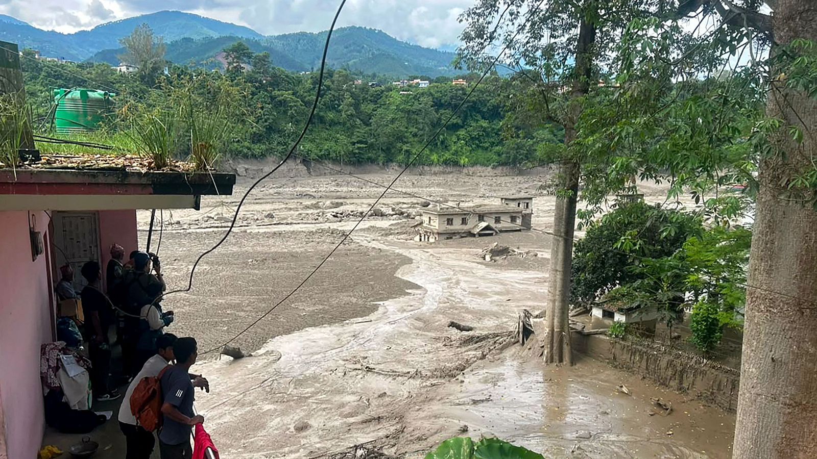 Varios residentes contemplan los efectos de la violenta riada que ha arrasado Nepal