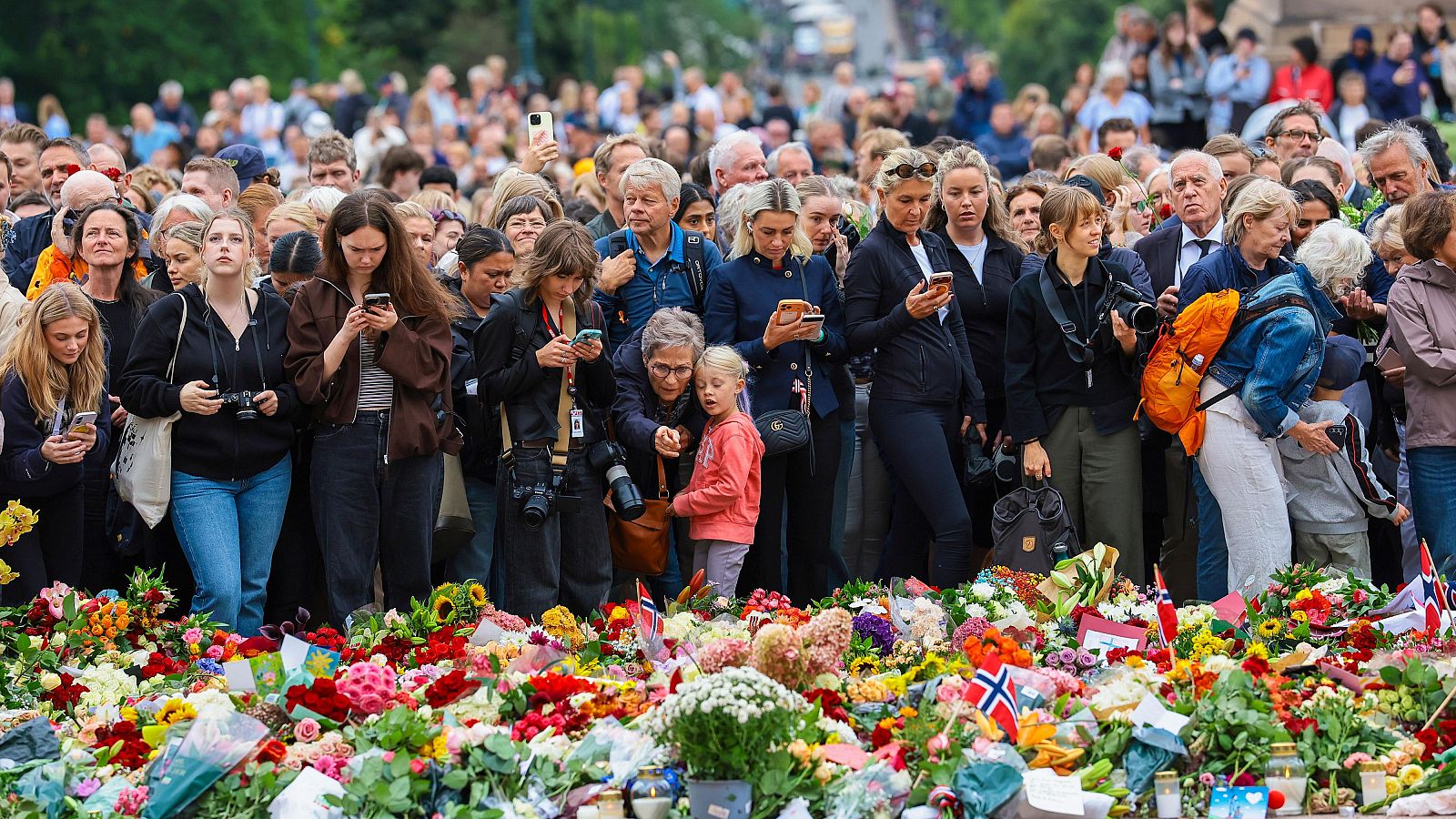 Varias personas depositan flores frente al Palacio Real de Oslo, en Noruega, tras el fallecimiento del rey Harald