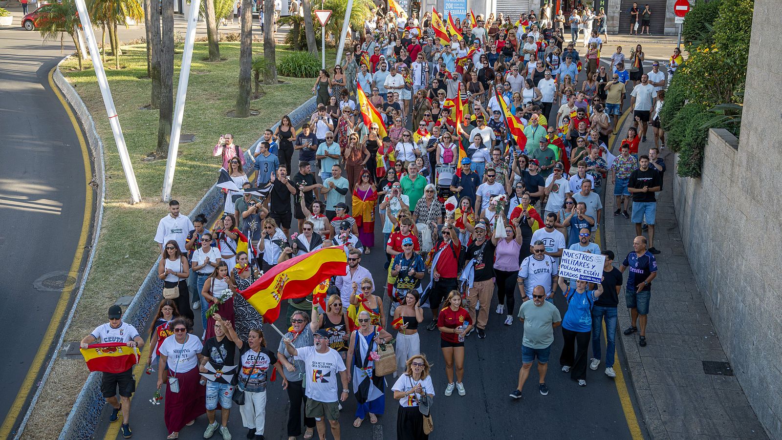 Un centenar de ceutíes se concentra ante la Delegación del Gobierno portando claveles y banderas de Ceuta y España para reivindicar el carácter pacífico de las movilizaciones