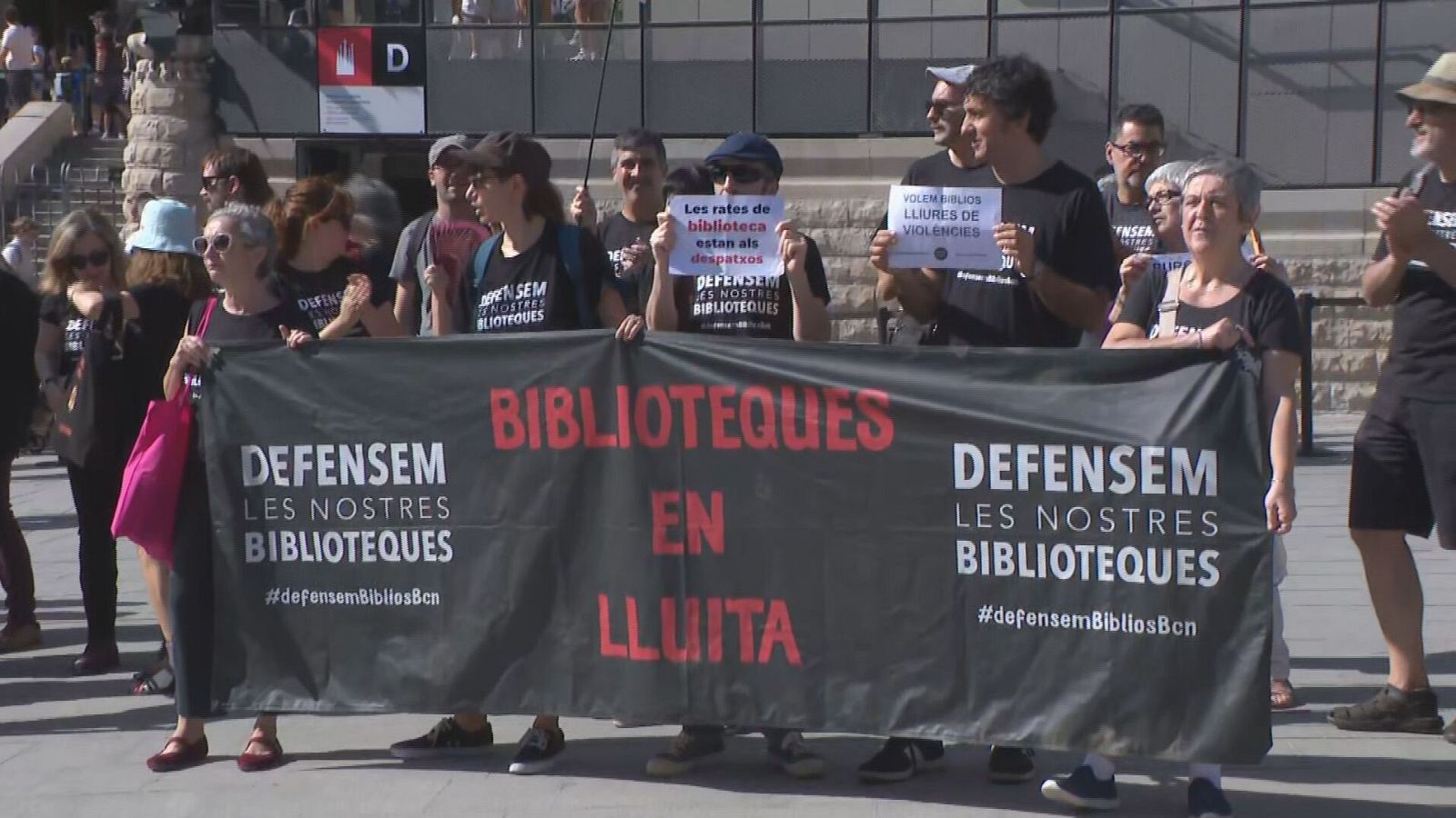 Manifestació a Barcelona en defensa de les biblioteques, amb pancartes que diuen "DEFENSEM LES NOSTRES BIBLIOTEQUES" i "BIBLIOTEQUES EN LLUITA".