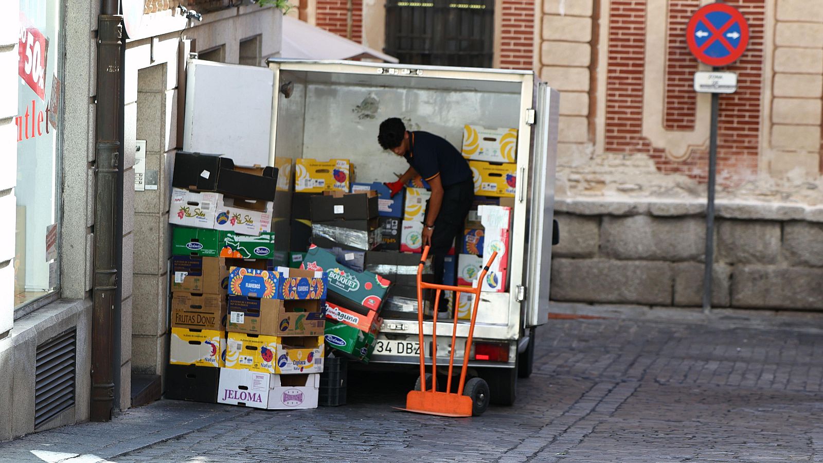 Trabajador descarga cajas de mercancía de un camión en una calle