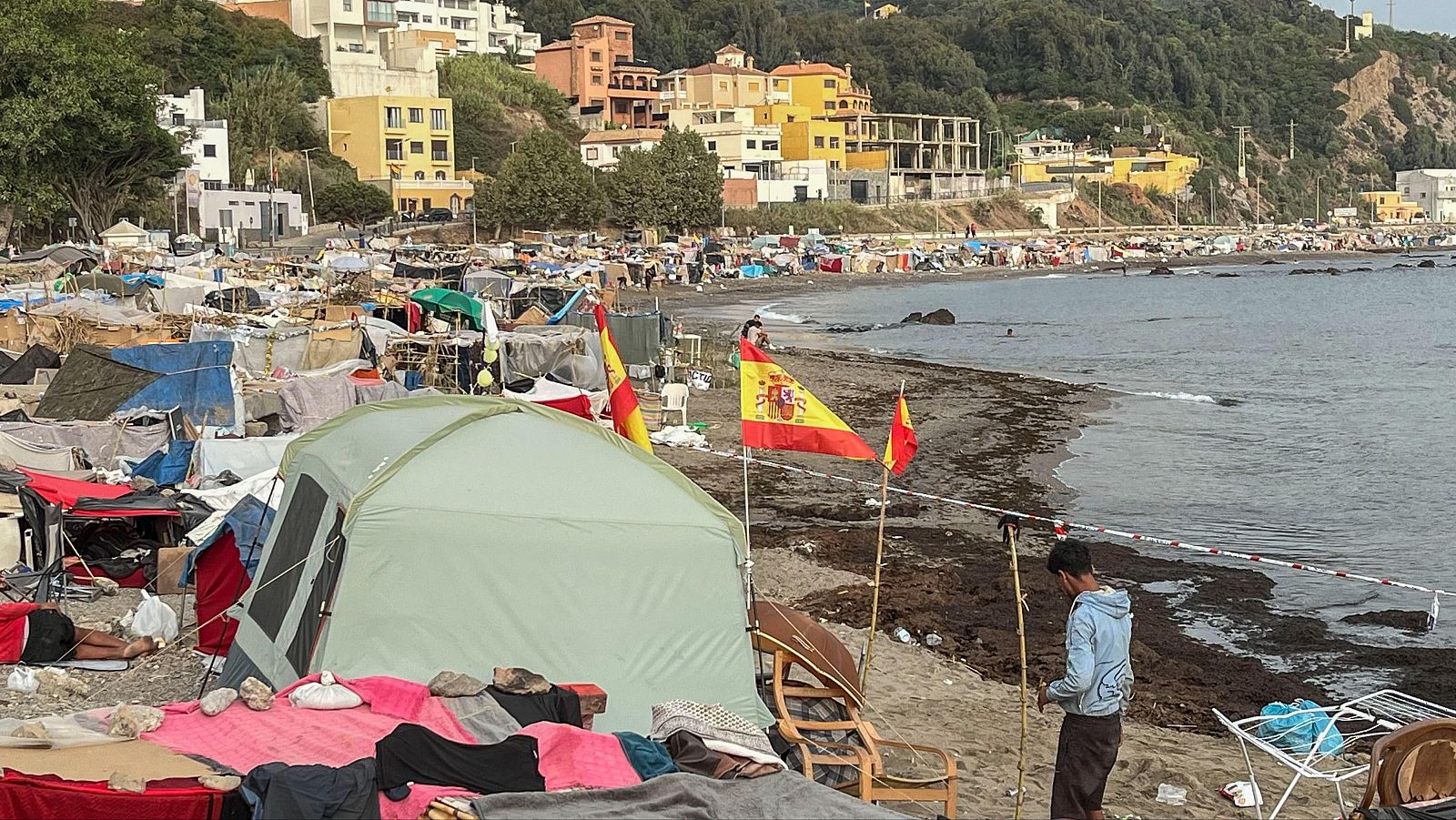 Ceuta: personas migrantes acampan en una playa de Ceuta