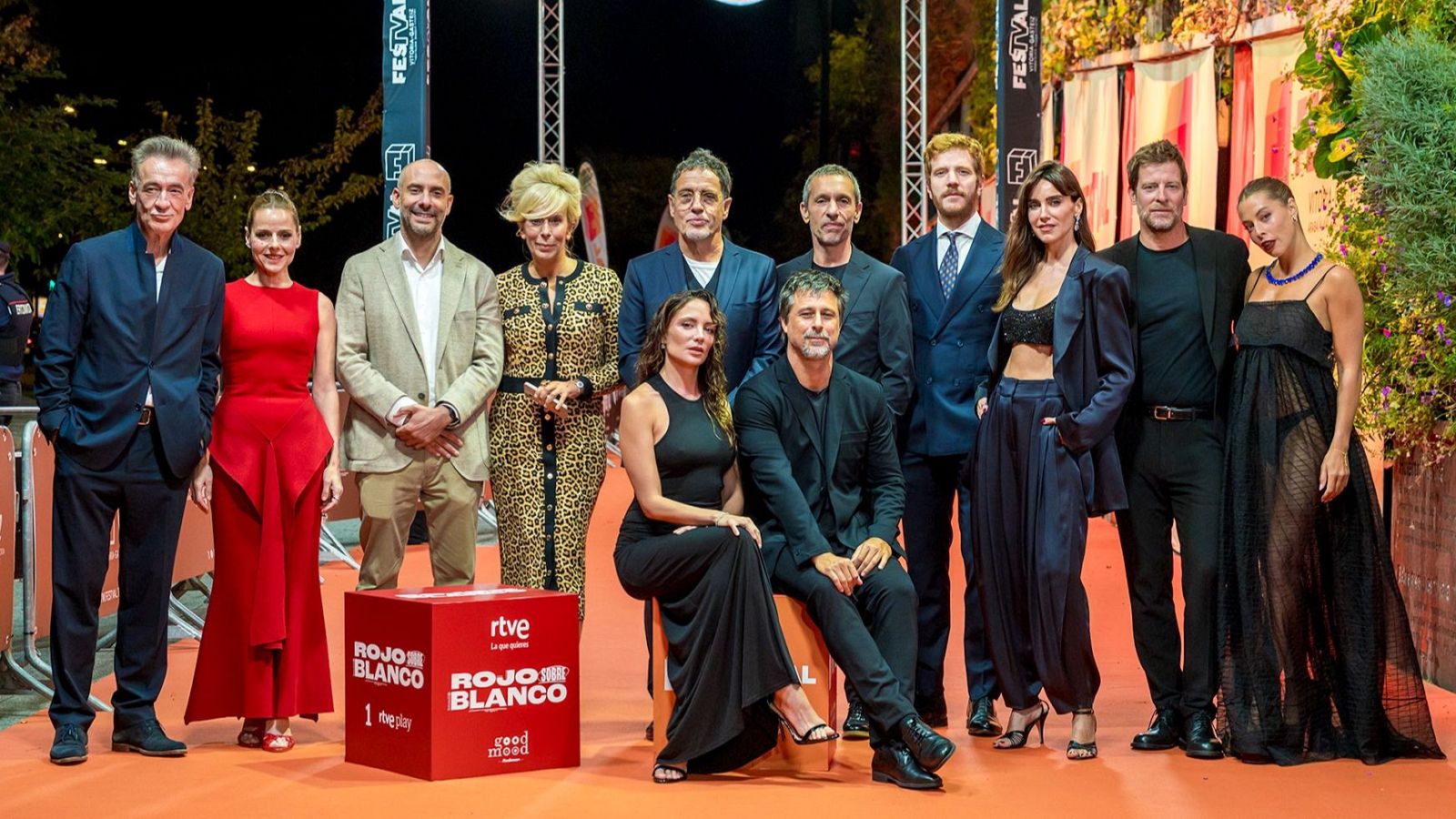 Periodistas españoles posan en la alfombra roja del FesTVal de Vitoria junto a un cubo de RTVE con el título 'Rojo sobre blanco'.